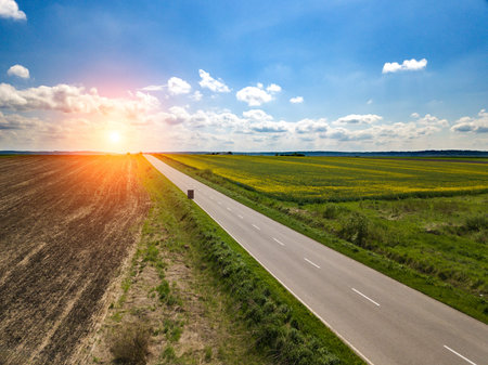 sunset in clouds with sunrays over road to horizon