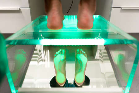 Orthopedic insole. The orthopedist works with the patient. Orthopedic clinic. Choice of insoles in an orthopedic clinic. The orthopedist offers the insole to the patientの写真素材