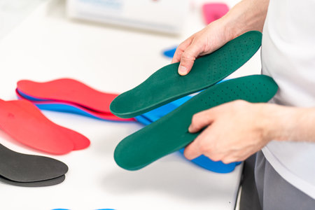 Orthopedic insole. The orthopedist works with the patient. Orthopedic clinic. Choice of insoles in an orthopedic clinic. The orthopedist offers the insole to the patient Foot careの写真素材