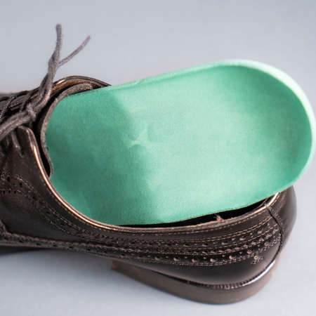 Orthopedic insoles for sports shoes. Treatment and prevention of flatfeet and orthopedic foot diseases. Foot care, feet comfort. Health care wearing comfortable shoesの写真素材