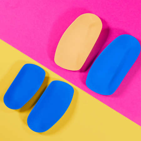 Foot support and healthy feet concept with orthopedic shoe insoles isolated color backgroundの写真素材