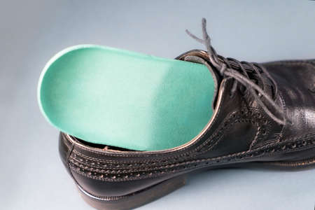 Orthopedic insoles for sports shoes. Treatment and prevention of flatfeet and orthopedic foot diseases. Foot care, feet comfort. Health care wearing comfortable shoesの写真素材