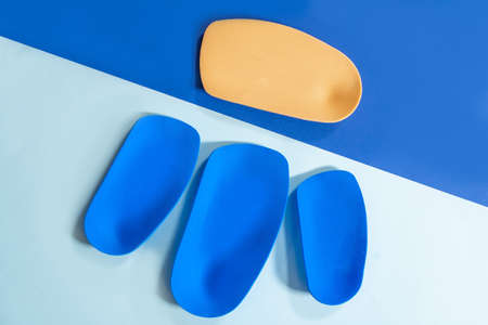 Foot support and healthy feet concept with orthopedic shoe insoles isolated color backgroundの写真素材