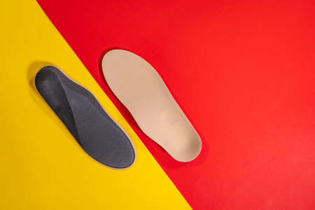 Foot support and healthy feet concept with orthopedic shoe insoles isolated color backgroundの写真素材