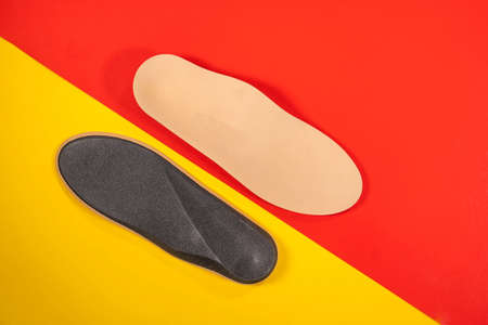 Foot support and healthy feet concept with orthopedic shoe insoles isolated color backgroundの写真素材