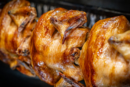 Barbecue roast Chicken in a row turning at industrial roasterの写真素材