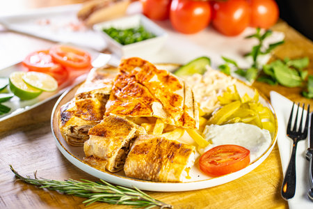 Chicken breast stuffed with butter, garlic and dill. Served with baked potato slices and fresh herbs.の写真素材