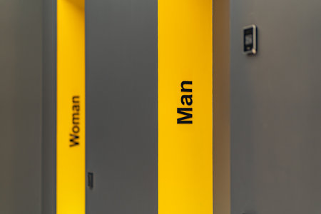 Perspective of a long corridor in office building. Doors of washrooms in hallway. Doors office with wc signs. Entrance to restrooms in a factoryの写真素材