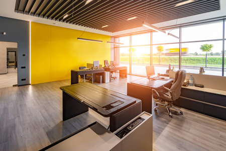 Modern office space with tables and chairs, computers and office supplies no employeesの写真素材