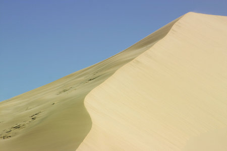 sand dune against blue skyの写真素材