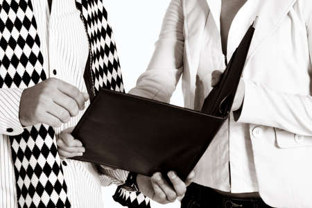 businesswoman and her partner with a black leather folder, soft sepia finishの写真素材