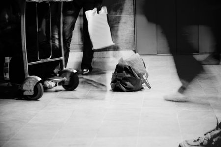 a shot of people's feet as they wait and walk through an airport - high-contrast grayscaleの写真素材