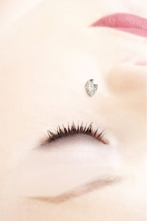 Tear shaped diamond on a cheek of young womanの写真素材
