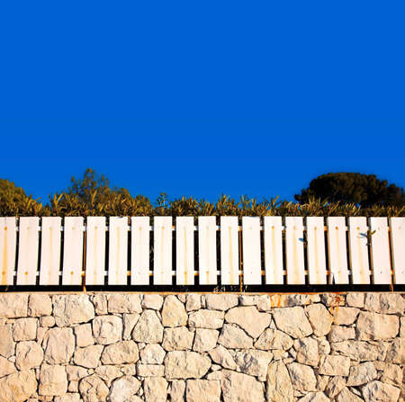 Blue sky background of a fence on a rustic wall in Franceの写真素材