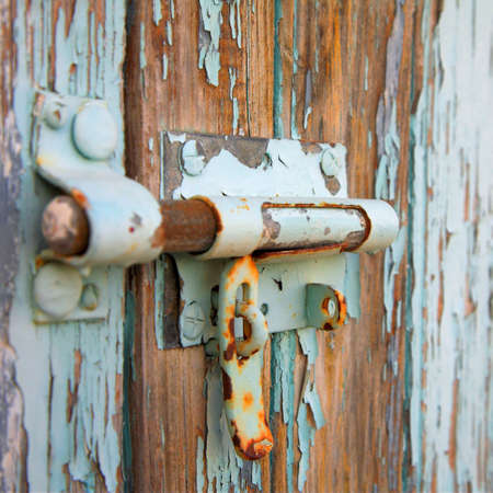 Close-up of a rusted lock on old wooden background with shallow DOFの写真素材