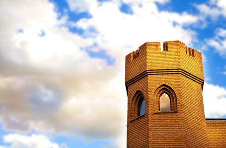 Brick tower of medieval castle on cloud background. Clouds are in soft focus, copy space. の写真素材