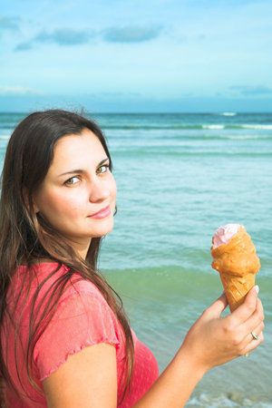 Beautiful woman with long brown hair and smile, caramel ice-cream. No sharpening