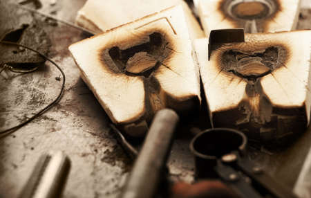 Old wooden jewelry molds for casting precious metals in a goldsmith workshopの写真素材