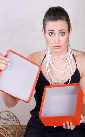 upset young woman with an empty red gift box - not isolated