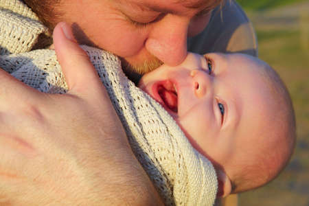 son and father  outside in evening sun- shot in natural light.の写真素材