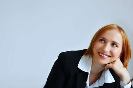 redhead businesswoman smiling. not isolated.の写真素材