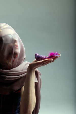 Woman in sunglasses and veil over her face holding a jewellery bird. From 16bit RAW.の写真素材