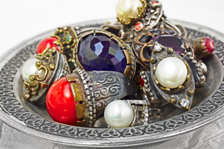 many Turkish Ottoman handmade rustic rings with pearls and corals on a silver plate.の写真素材