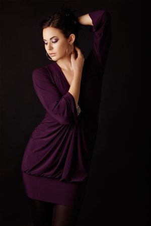 Beautiful fashion model in a purple mini dress and tights, wearing purple eyeshadows .の写真素材