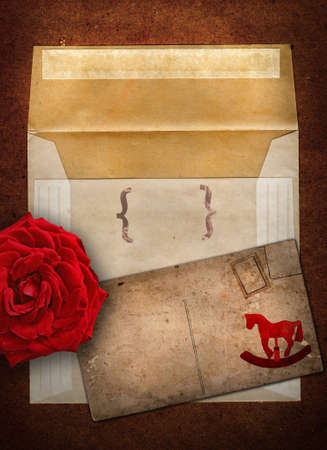 grunge envelop and card set with rocking horse design and red rose on copy spaceの写真素材
