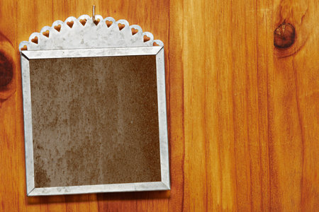 silver sink frame with hearts design and grunge insert hanging on wooden wall with copy space.の写真素材