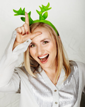 young beautiful woman wearing reindeer horns making fun.の写真素材