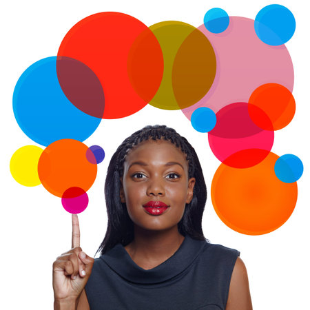 Portrait of a happy African American business woman pointing up with a smile on white background with thought bubbleの写真素材