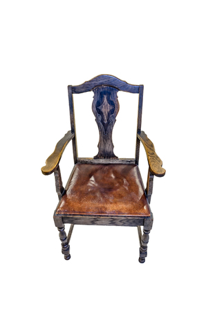 Ancient wooden, carved chair with armrests and leather seat on a white backgroundの写真素材