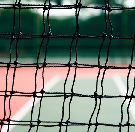 red and green Tennis court from the square holes of net.の写真素材