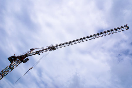 Long construction crane with blue sky as background