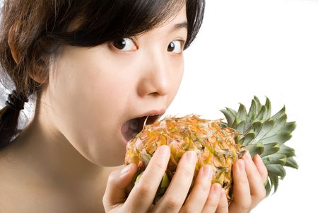 Young asian female holding a ripe and fresh pineapple. isolated picture shot in studioの写真素材