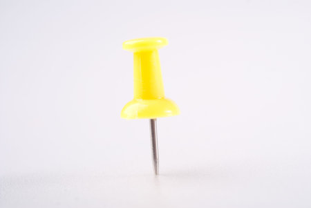 Yellow single pin in white board isolated