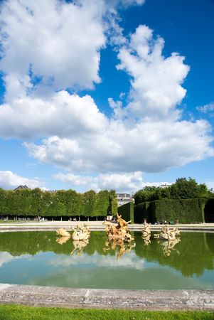 Classic fountain in paris royal park with water reflectionの写真素材