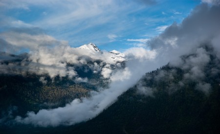 mountain landscape with green trees covered and white cloudscapeの写真素材