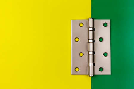 Stainless steel hinges on a yellow and green background. Copy space.の写真素材