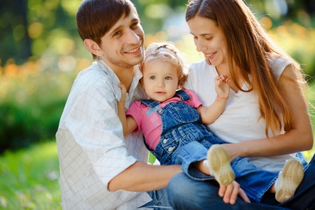 Happy family of three people relaxing in a city park. Happy family concept of the good lifeの写真素材