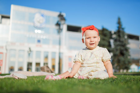 Happy baby posing in front of a beautiful building in the city parkの写真素材