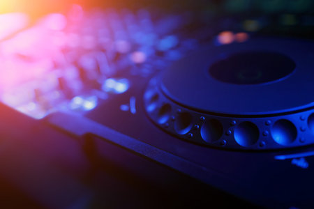 DJ mixer with light colored spotlights discos, shallow depth of field and beautiful swirling bokeh