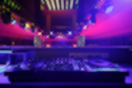 DJ mixer with light colored spotlights discos, shallow depth of field and beautiful swirling bokehの写真素材