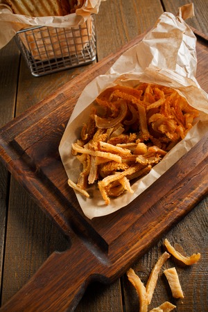 Smoked pork ears, thinly sliced filed in paper envelope on a wooden boardの写真素材
