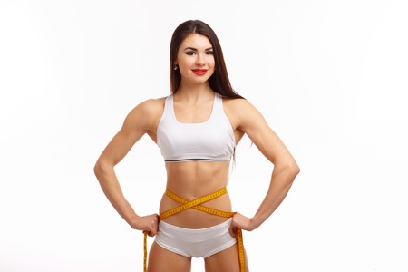 Sporty woman and measure around her body on white backgroundの写真素材