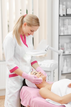 Face Lifting. Young woman getting facial massage in the cosmetology salon. Procedure of facial massage in cosmetology. Face Skin Care. Lifting Procedure. Cosmetology Salon. Cosmetology Face Massage.の写真素材