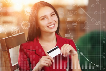 Business woman holding credit card and looking at the camera. Woman pays for a purchase with credit card. Purchase on the Internet. Buy and shopping online. Business infographicの写真素材