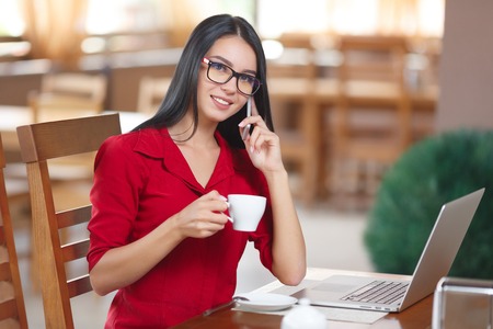 Young business woman holding mobile phone and credit card. Woman pays for a purchase with credit card. Purchase online. Shopping onlineの写真素材