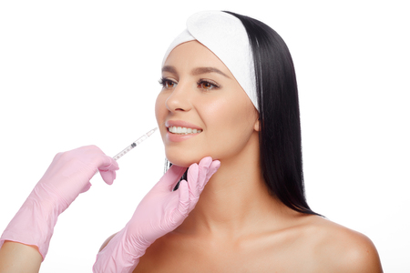 Young woman gets injection in her lips. Close-up woman hyaluronic acid injection in lips. Injections of skin rejuvenation. Cosmetic procedures, injections, hyaluronic acid.の写真素材